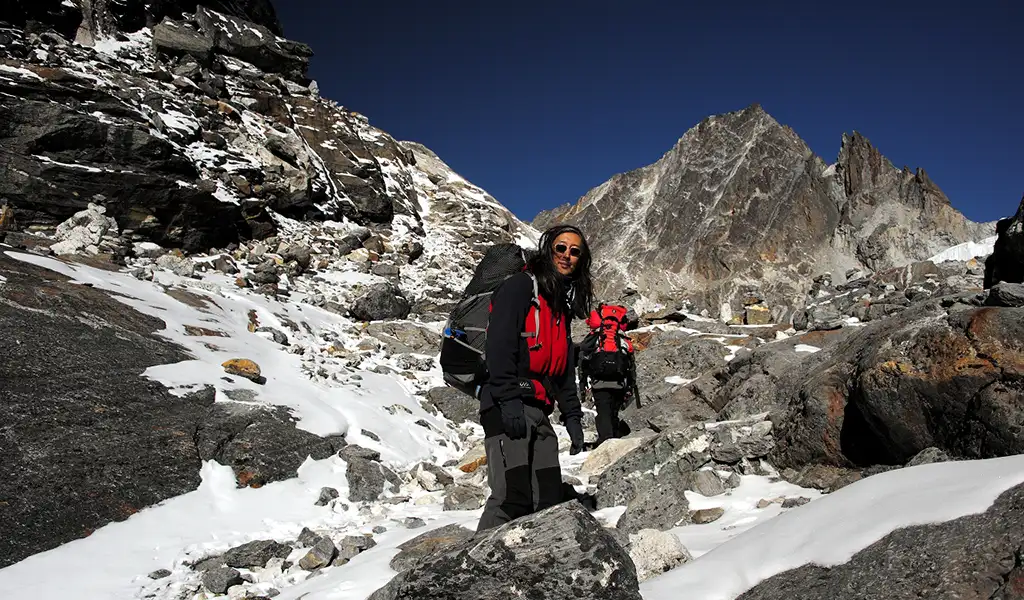 Trekkers navigate a steep, snowy glacier near the summit of a high-altitude pass, a challenging section of the Everest Three Passes Trek.