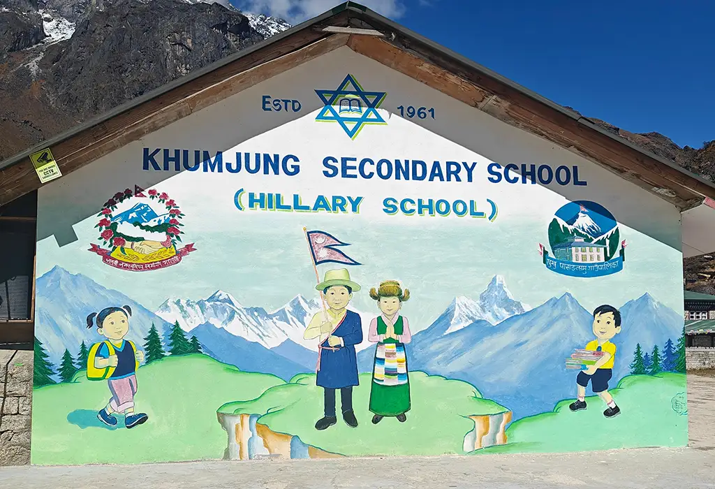 A vibrant colorful mural on the Khumjung Secondary School building depicts students and the Himalayas, a site often visited during Island Peak climbing treks.