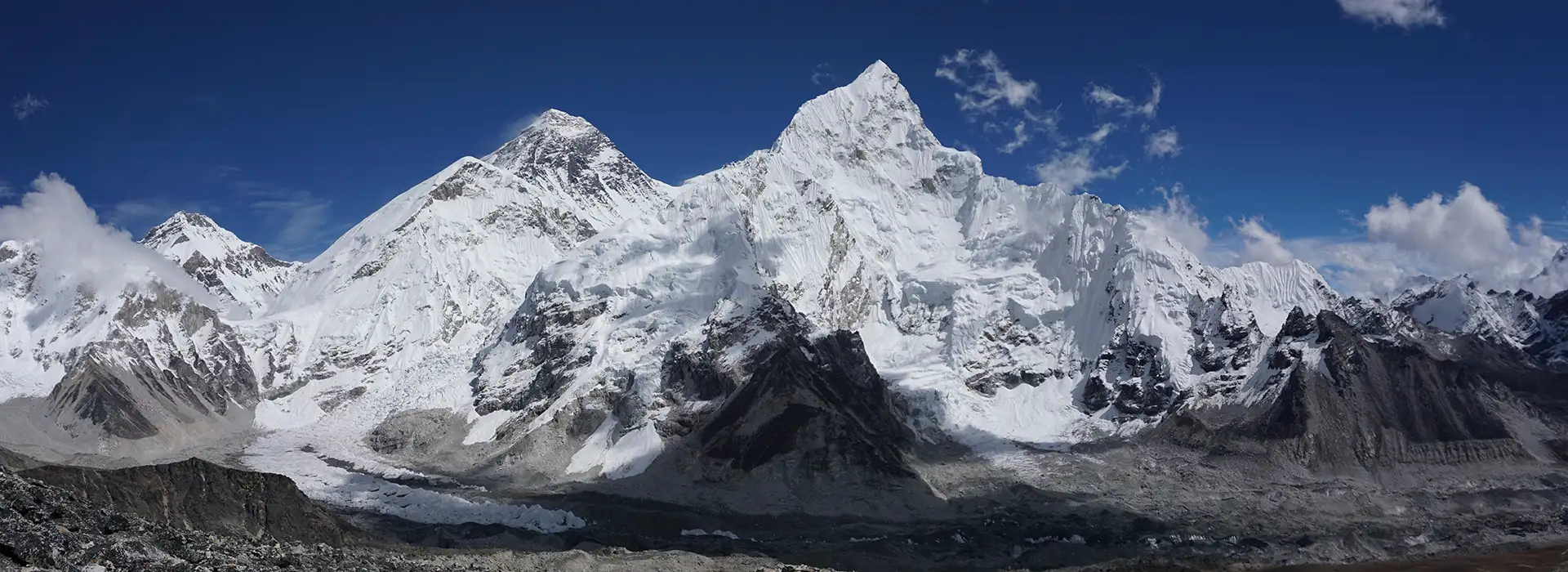 A sweeping panoramic view of Mount Everest, Lhotse, and Ama Dablam under a clear blue sky, a signature sight of the Everest Panorama Trek.