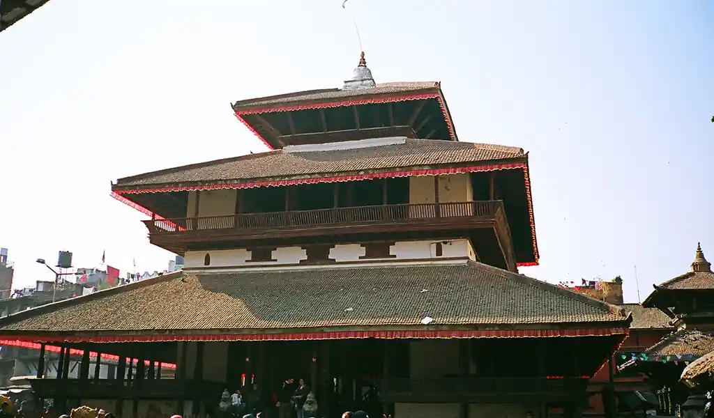 Kasthamandap temple pavilion at Kathmandu Durbar Square, Nepal, featuring a three-tiered pagoda-style roof and traditional wooden architecture.