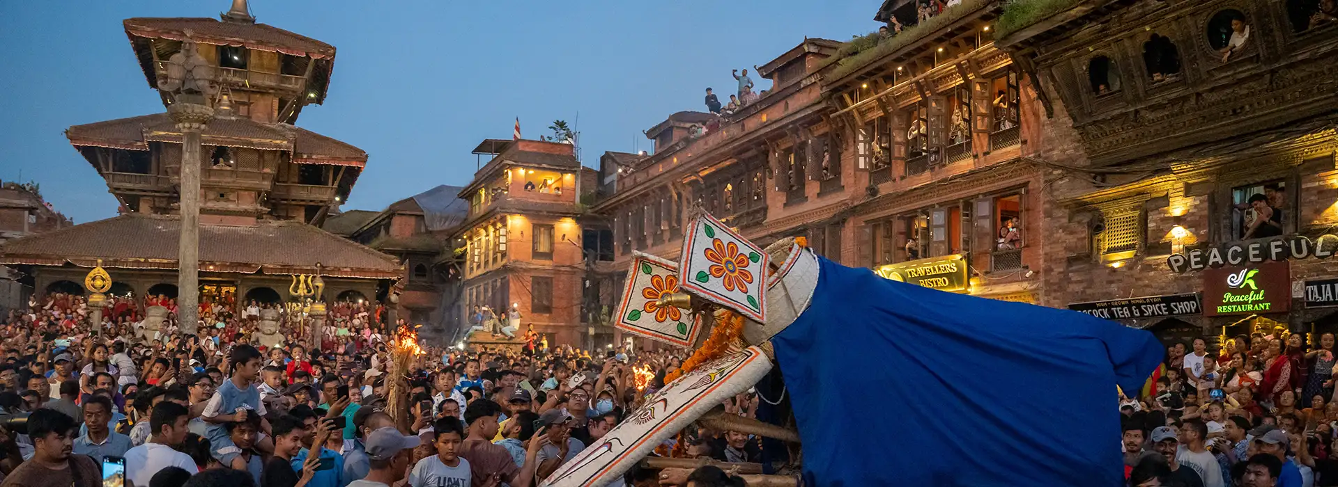 Crowds gather at Kathmandu Durbar Square during an evening festival with a towering chariot procession, captured as part of a Nepal and Bhutan tour showcasing living Himalayan culture and heritage.