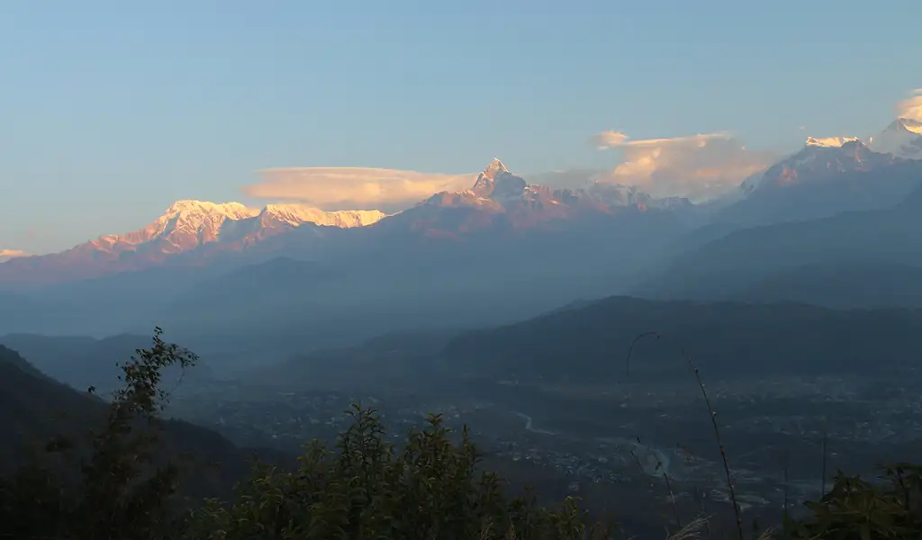 Sarangkot sunrise view with Machapuchare peak and the Annapurna range glowing in soft light above the Pokhara Valley.