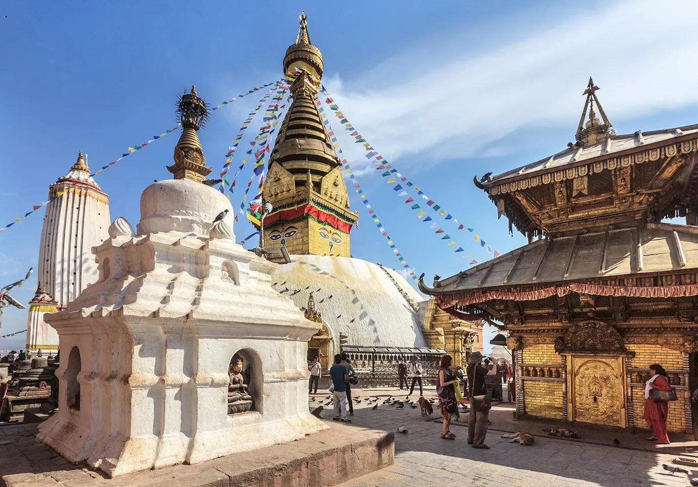 Swayambhunath Temple Kathmandu Nepal with prayer flags, golden stupa, and visitors walking around the sacred complex.