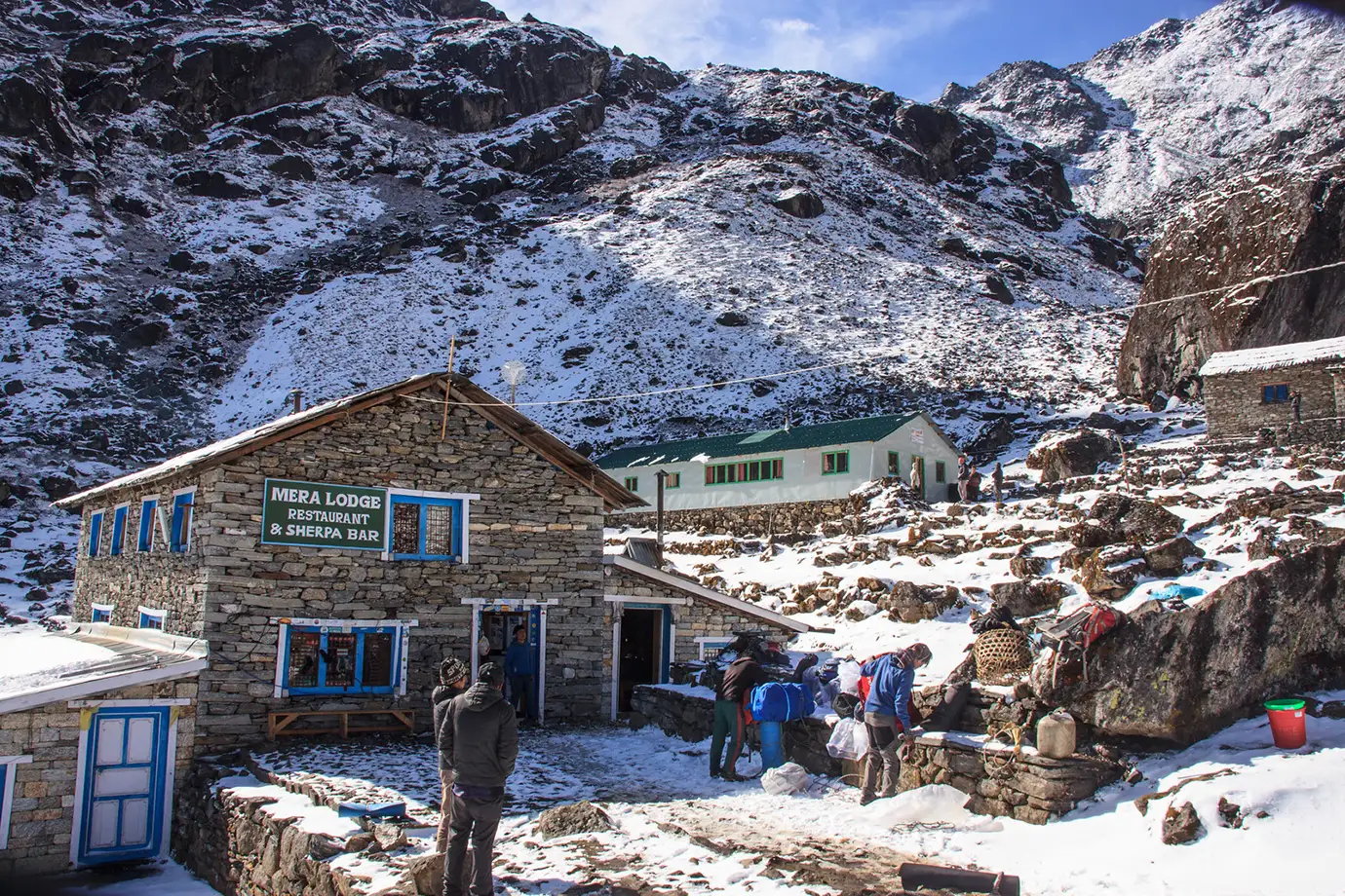 Mera Lodge and nearby teahouses at Thuli Kharka, surrounded by snow-covered Himalayan slopes.