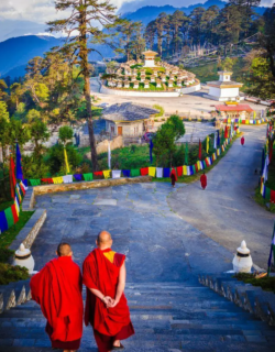 Monks walking near chortens at Dochula Pass, Bhutan.