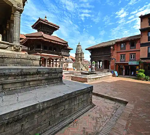 Stone temples and brick buildings line a historic square with pagoda-style structures under a blue sky.