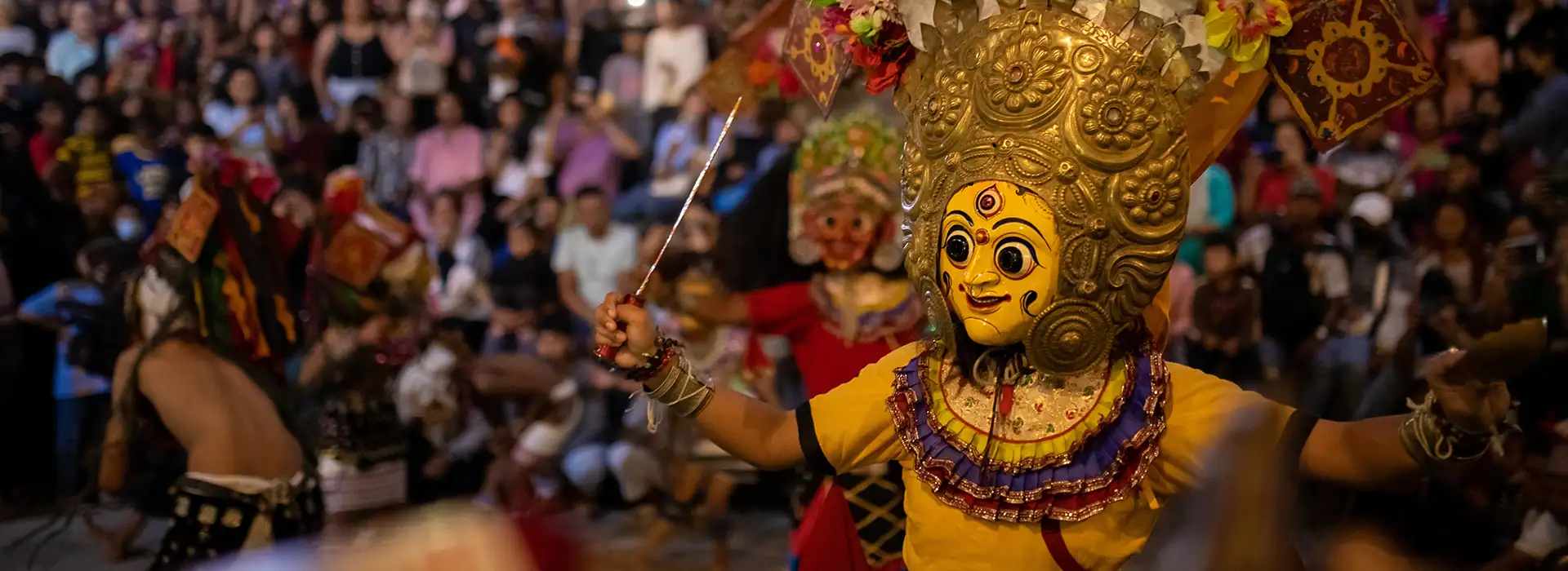A masked dancer performs a traditional ritual dance during a lively evening festival in Kathmandu, a cultural highlight often experienced on a Nepal trekking tour that blends mountain trails with living heritage.