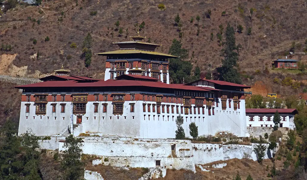 Rinpung Dzong fortress in Paro, Bhutan, perched on a hillside with traditional Bhutanese architecture and whitewashed walls.