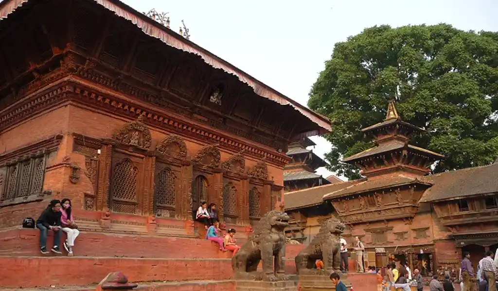 Shiva Parvati Temple in Durbar Square, Nepal, featuring red-brick Newar architecture, carved wooden windows, and stone lion statues in the courtyard.