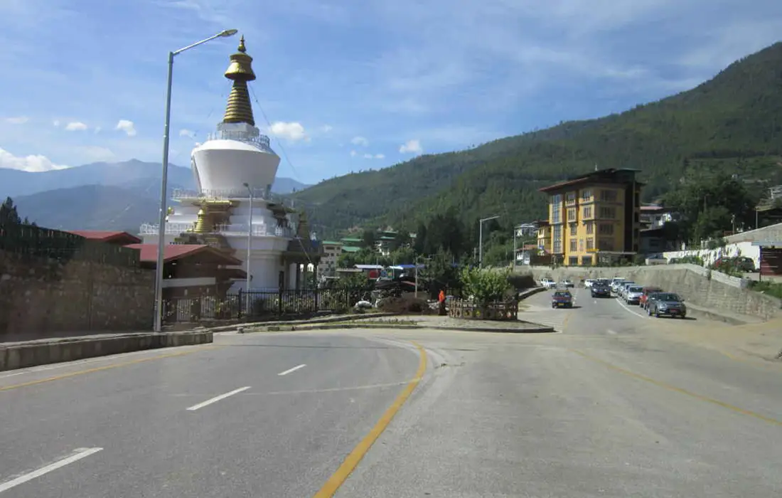 City road near white stupa in Bhutan, suitable for Bhutan travel for senior travelers