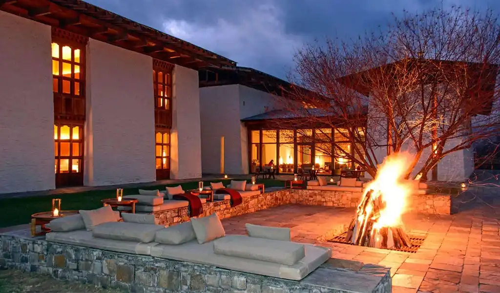 A cozy outdoor bonfire area with plush sofas at Amankora luxury resort, perfect for a Bhutan honeymoon tour.