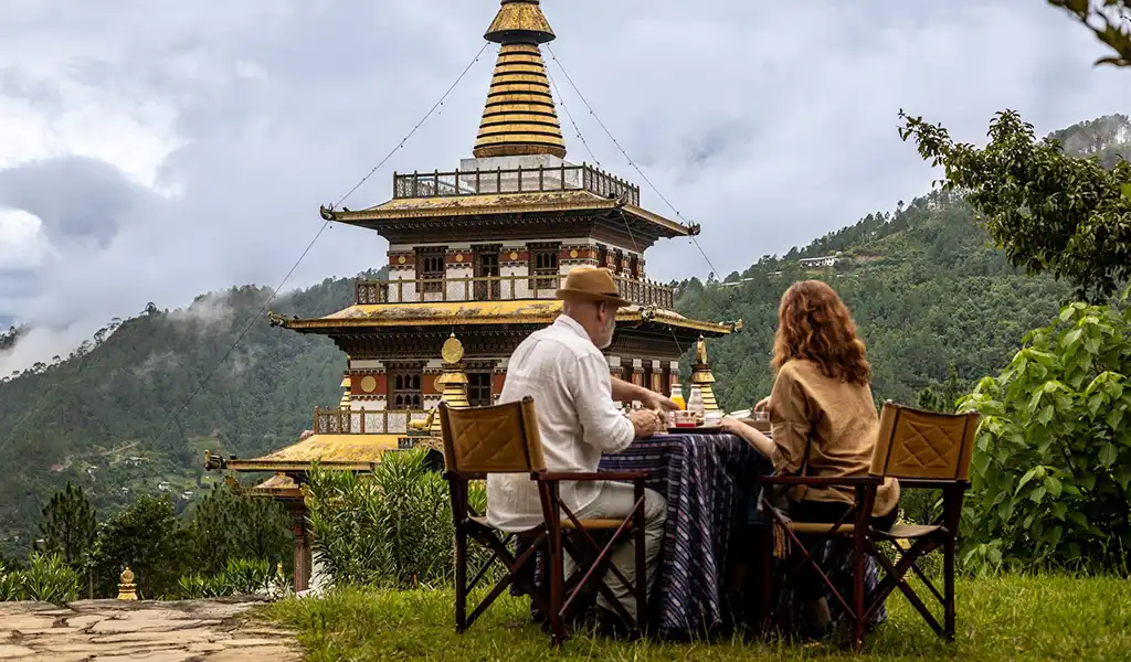 A romantic private dining table set outdoors with a mountain view during a Bhutan honeymoon tour.