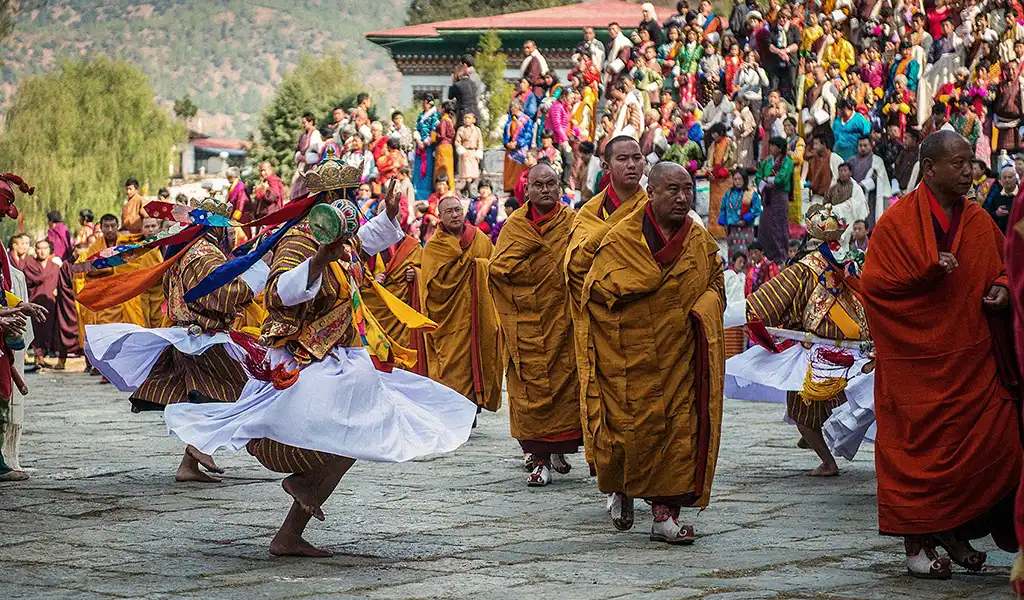 Masked dancers and monks perform a traditional Cham dance during a Bhutan spiritual tour festival.