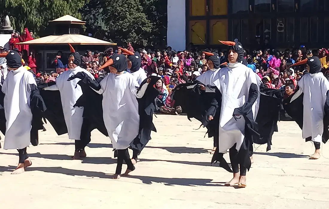 Children performing crane dance at festival under clear skies reflecting Bhutan's Weather in autumn