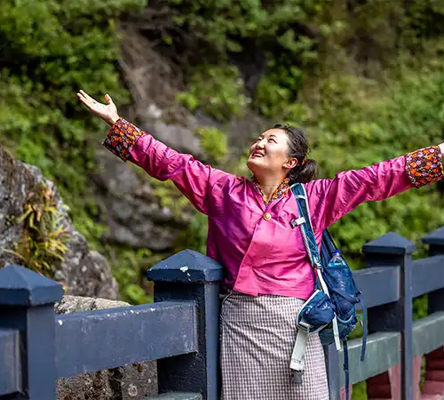 A happy traveler smiling while exploring the serene mountains, perfect inspiration for solo travel in Bhutan.