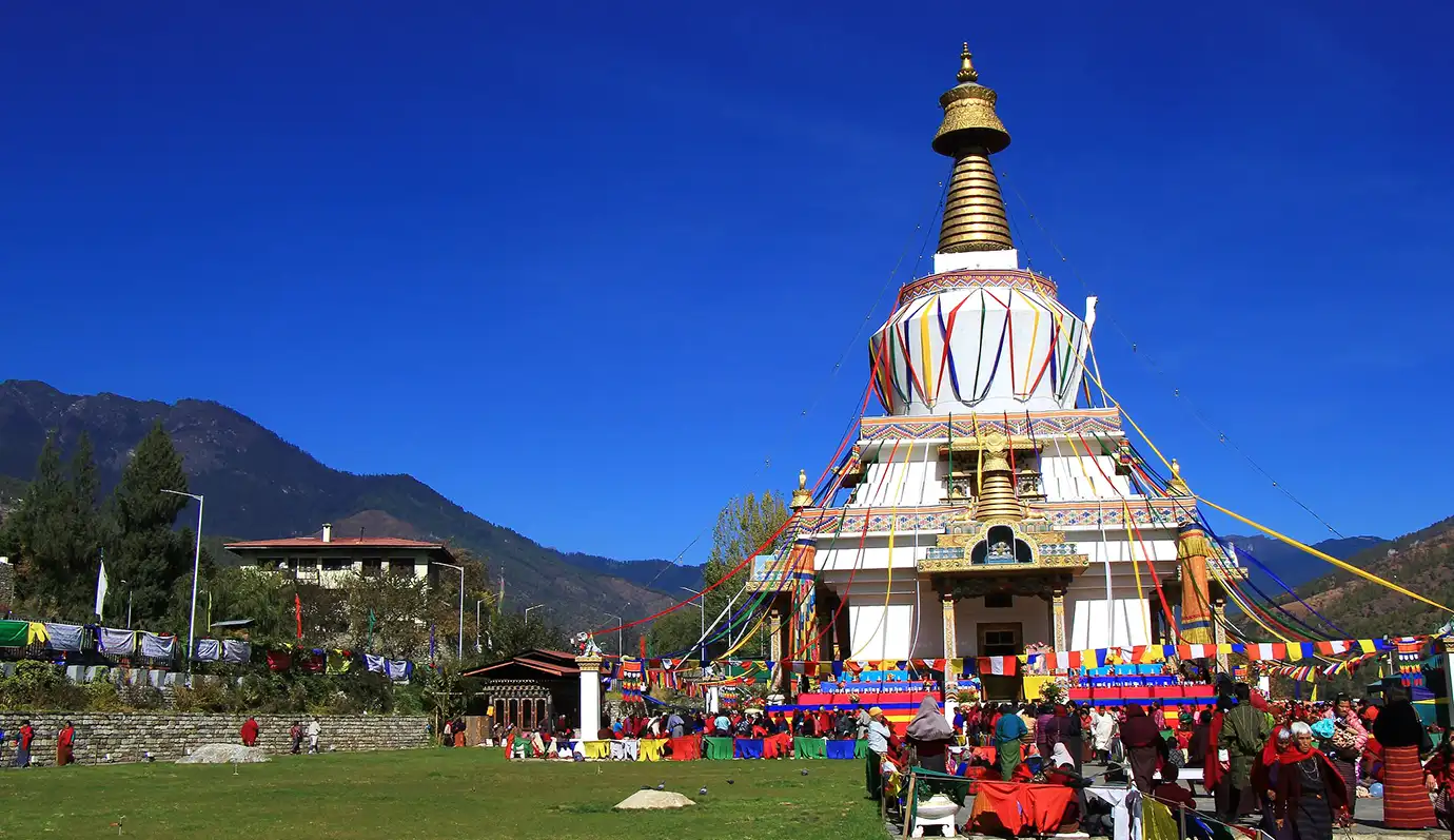 National Memorial Chorten in Thimphu decorated with prayer flags and visitors gathered, featured in Bhutan Travel Guide.