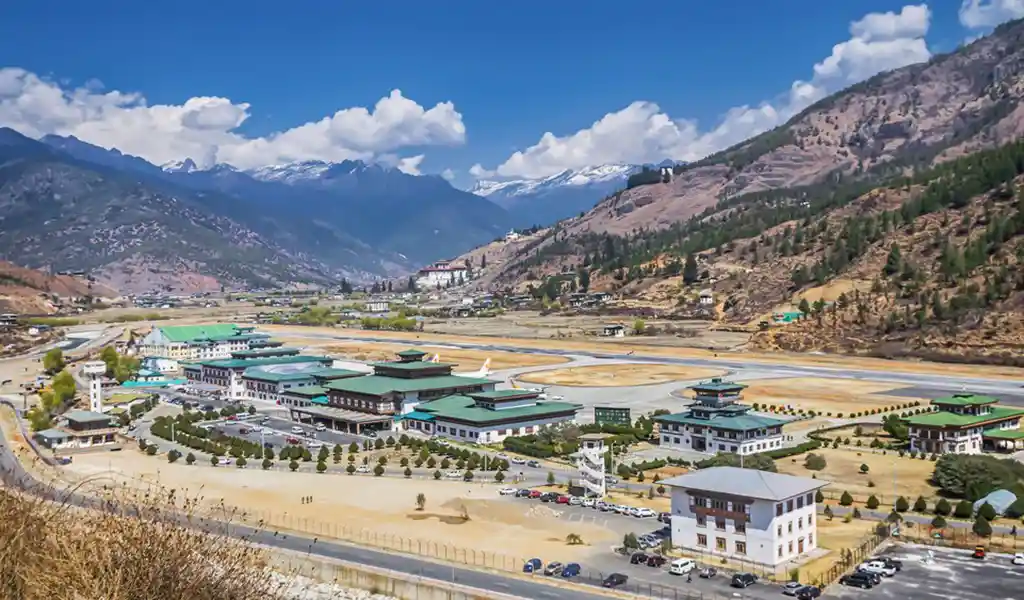 A wide view of Paro International Airport terminal with traditional architecture, a key entry point for luxury travel in Bhutan.