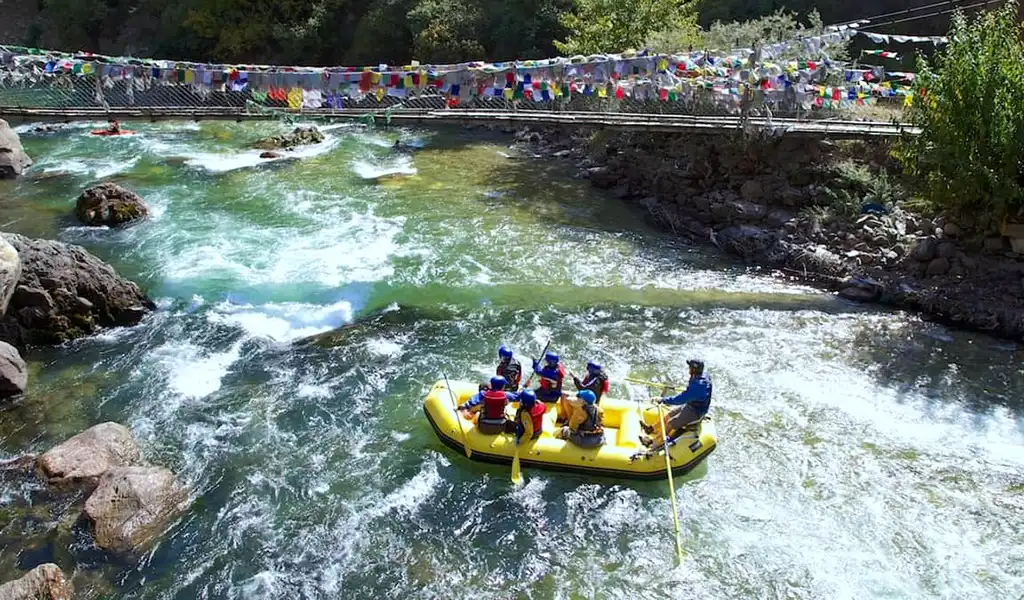 A family enjoys a safe white-water rafting adventure on the gentle turquoise waters of the Paro Chhu river in Bhutan.