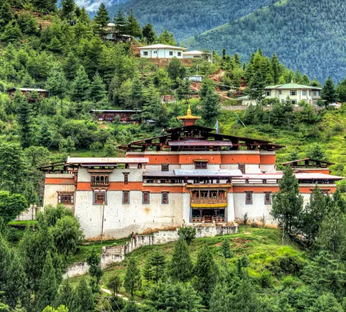 Traditional Bhutanese monastery in Thimphu Valley surrounded by green forested hills, Bhutan Travel Guide.