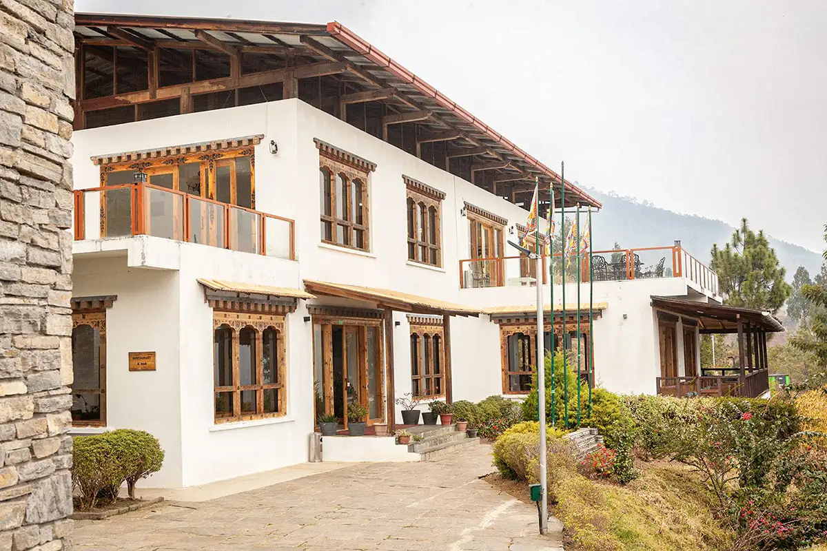 Zhingkham Resort Punakha exterior with landscaped gardens and mountain backdrop in a Bhutan accommodation guide.