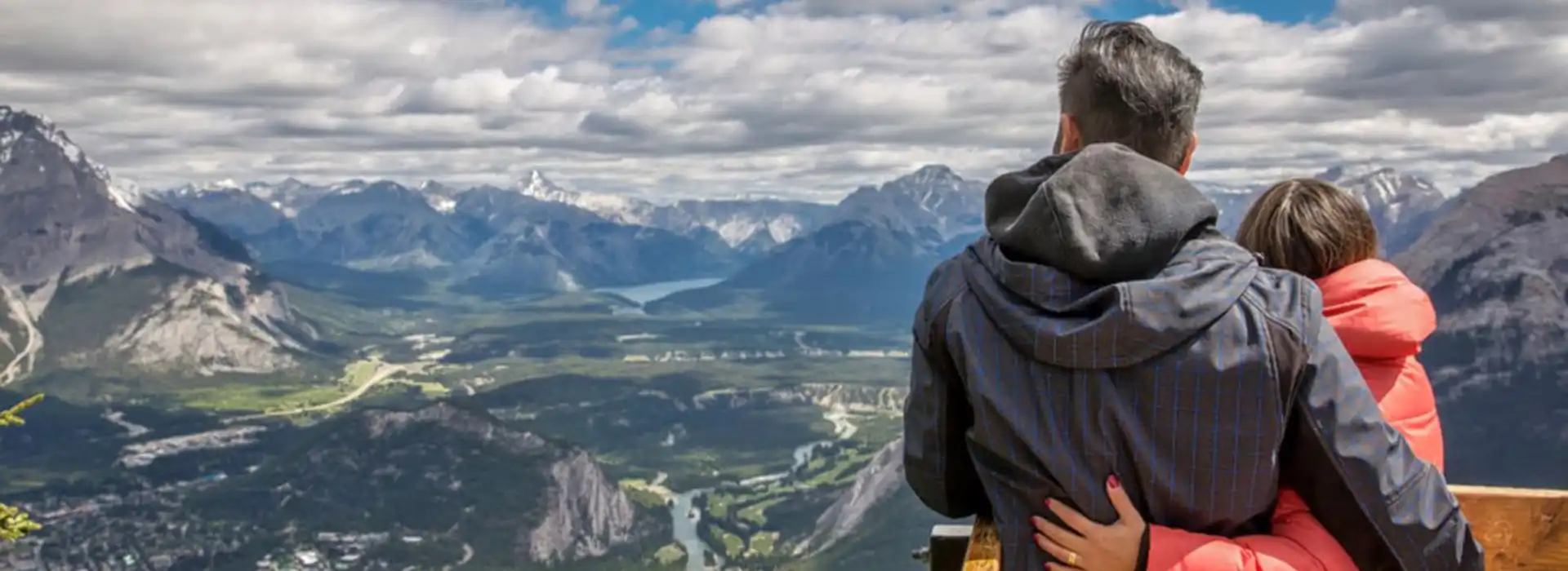 A romantic couple with their backs to the camera, looking out over the majestic mountains and valleys of Bhutan.