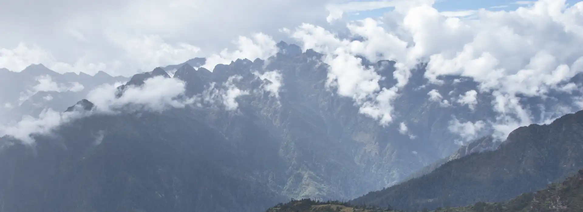 A scenic view of the rugged Himalayan mountains under a cloudy sky, captured during a Druk Path trek in Bhutan.