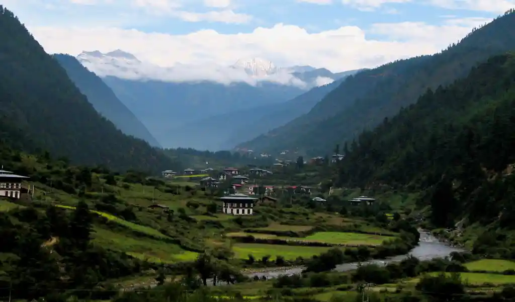 A landscape view of the secluded Haa Valley with traditional houses and lush forests, one of the most authentic places to visit in Bhutan.