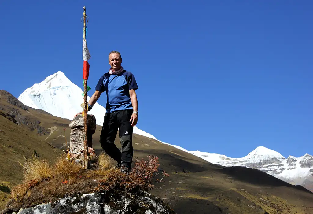 Trekker standing near Mount Jomolhari in Bhutan showcasing high-altitude hiking experience featured in Bhutan travel tips.