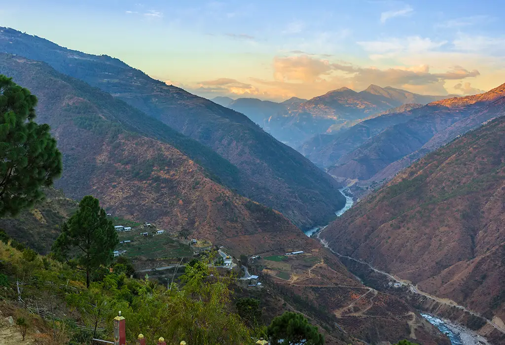 A sweeping panoramic view of a lush green valley and traditional architecture, a must-see location featured in any Bhutan travel guide.