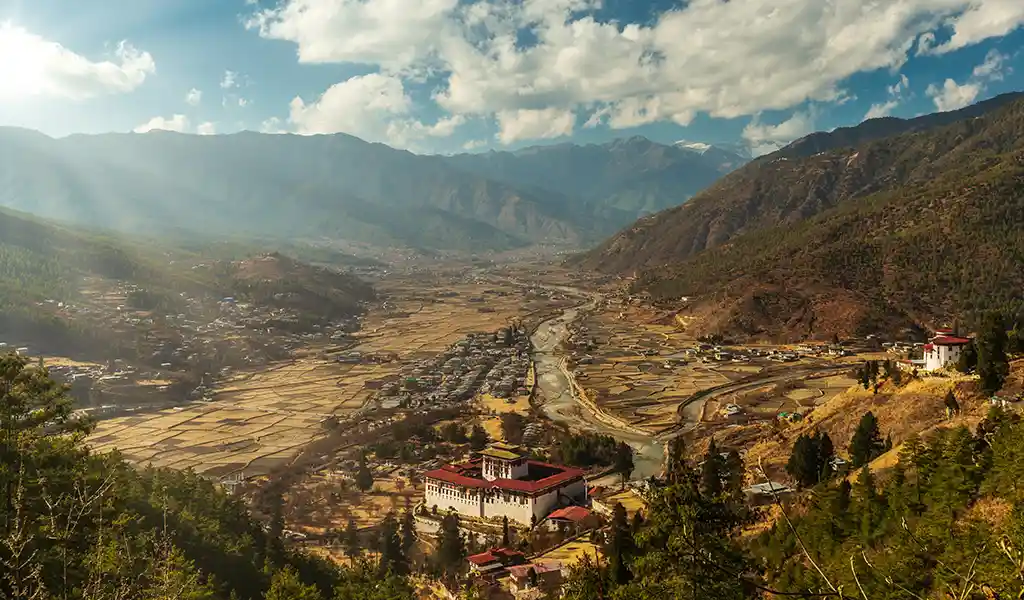 A wide view of the terraced rice paddies and traditional houses in the Paro Valley, one of the top places to visit in Bhutan.