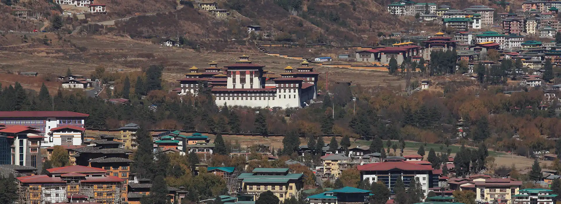 A stunning view of a Bhutanese monastery under clear blue skies, representing the best time to visit Bhutan during the peak seasons.