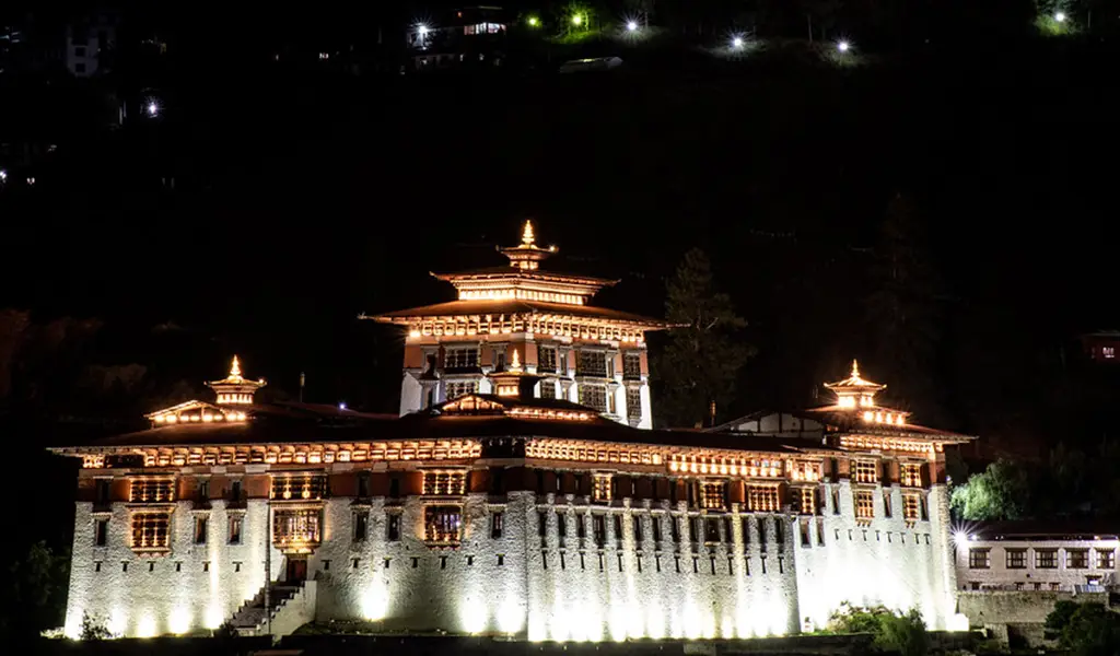 Rinpung Dzong illuminated at night in Paro Bhutan, a scenic cultural stop during a Bhutan road trip.