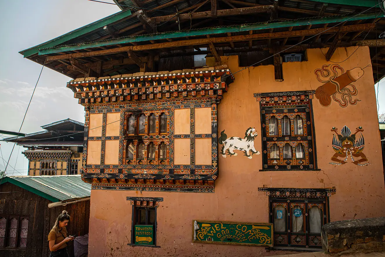Traditional Bhutanese house with colorful wooden windows and wall paintings reflecting authentic Bhutan village life.