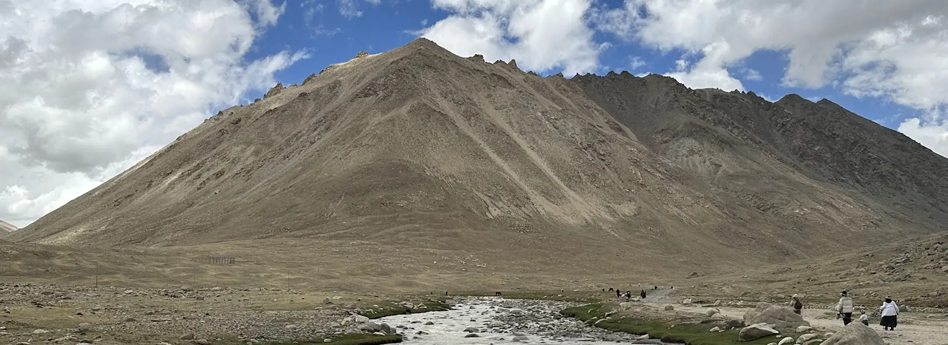 Wide mountain landscape on the Kailash Kora route during a Tibet Private Tour vs Group Tour, showing the remote terrain and open trail conditions.