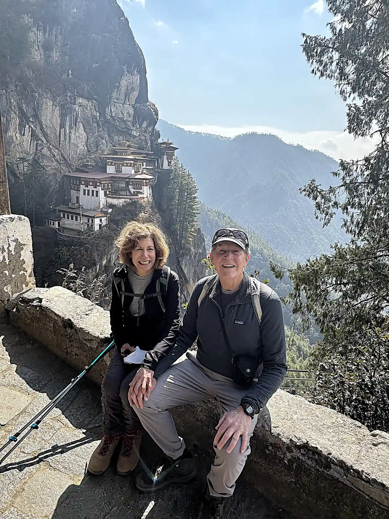 Travelers resting during the hike to Tiger’s Nest Monastery in Bhutan, showing trekking conditions that highlight the importance of a Bhutan Travel Packing List for mountain hikes.