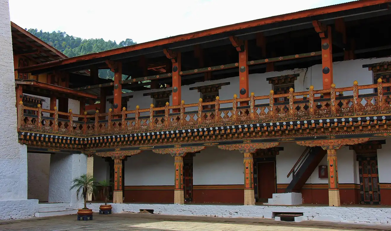 Interior courtyard of Punakha Dzong featuring traditional wooden balconies and intricate Bhutanese architectural details inside a historic Bhutan Dzong monastery.