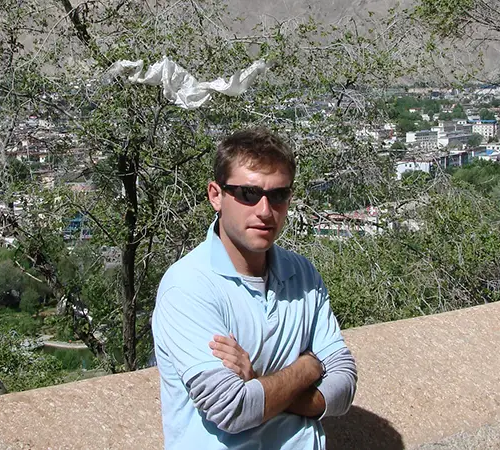 Traveler standing at a scenic viewpoint above Lhasa with the city in the background