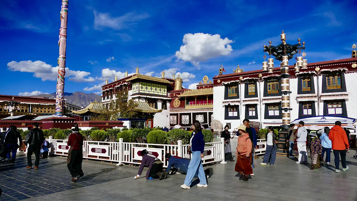 Pilgrims walk and pray outside Jokhang Temple in Lhasa, an important cultural stop for travelers on a Tibet Tour from Singapore.