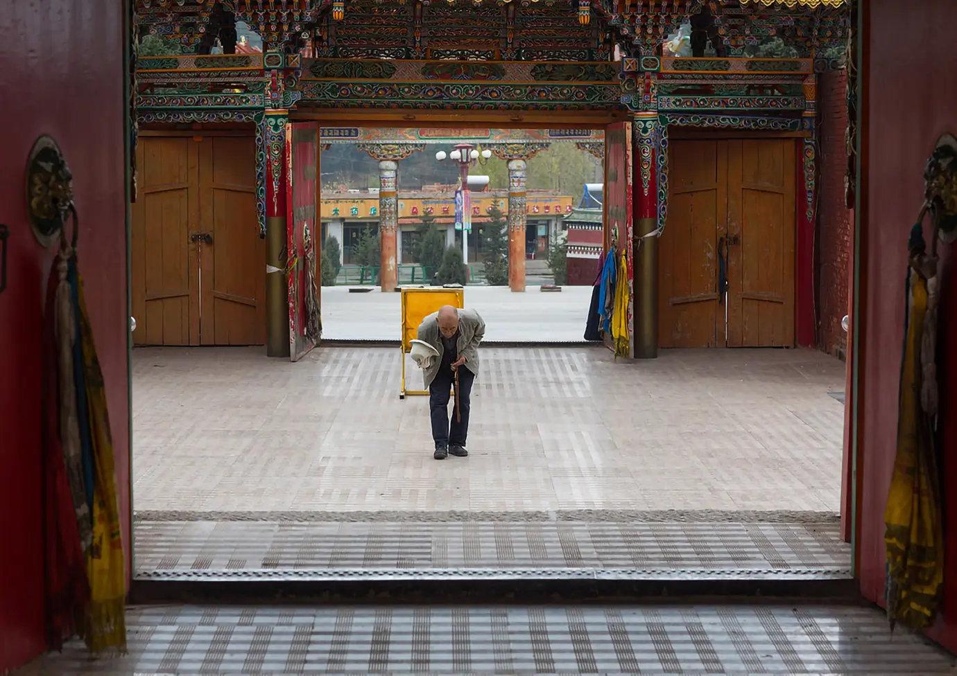 Tibetan local bowing inside a monastery during a Tibet Private Tour vs Group Tour visit, showing a quiet moment of devotion in a sacred setting.
