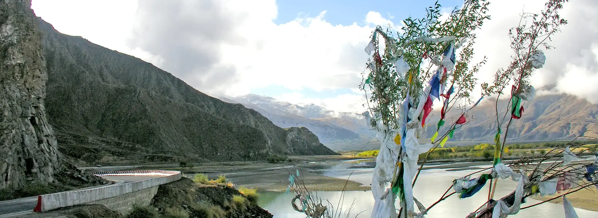 Remote mountain road and river valley in Tibet where travelers must consider who should avoid traveling to Tibet due to high altitude conditions.