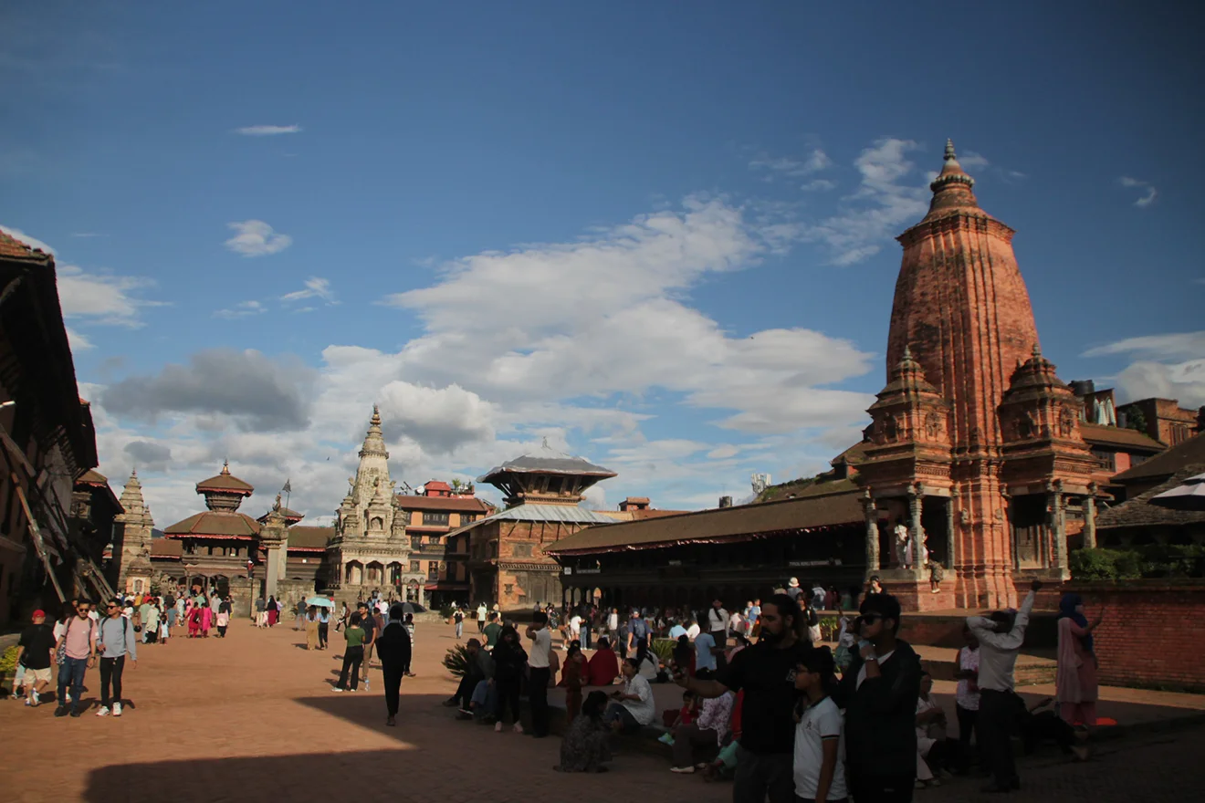 Visitors walk through the historic Bhaktapur Durbar Square under a bright sky. This ancient city is a cultural gem among Nepal bucket list destinations.
