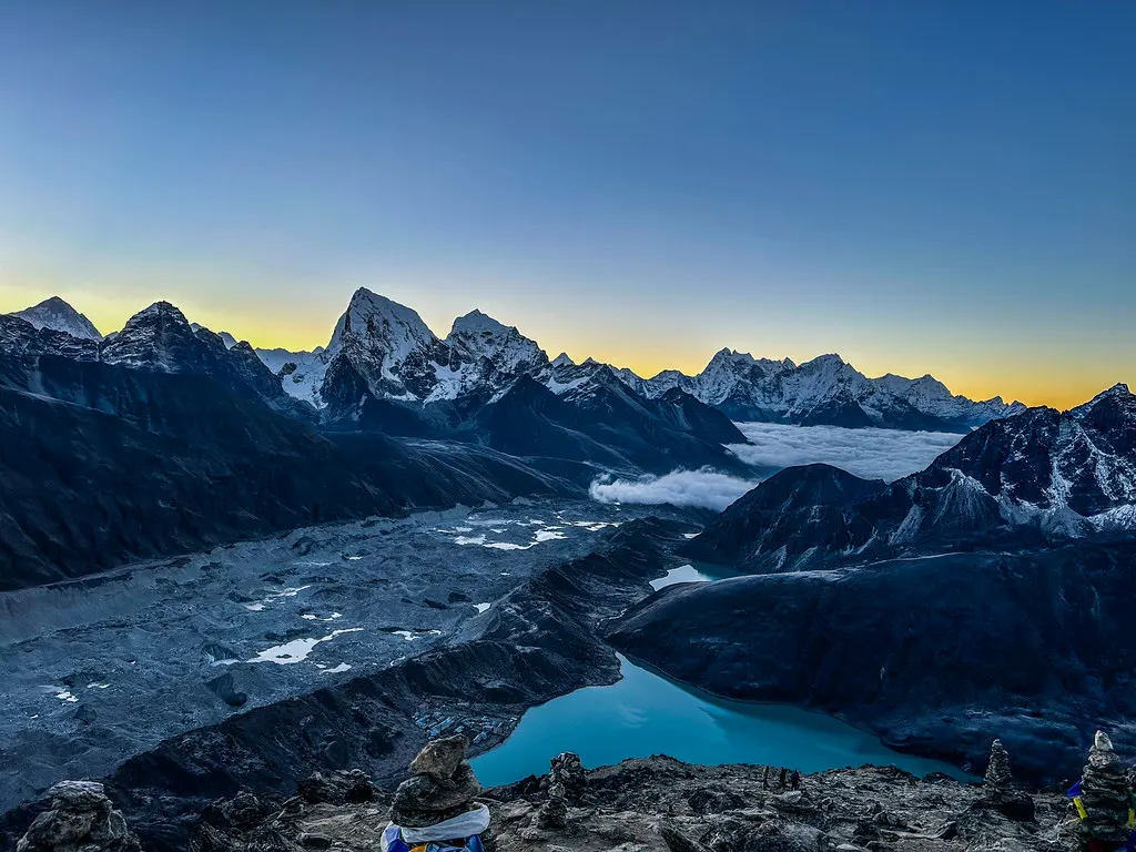 A panoramic view of Gokyo Lakes and the Ngozumpa Glacier at dawn, showcasing a premier destination along the rugged Everest Three Passes Trek.