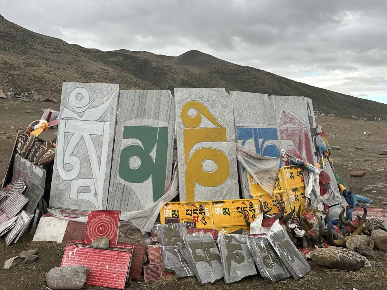 Large Mani stones carved with Tibetan Buddhist mantras sit along the trekking trail. These sacred markers are a common sight for travelers following a Mount Kailash packing list.