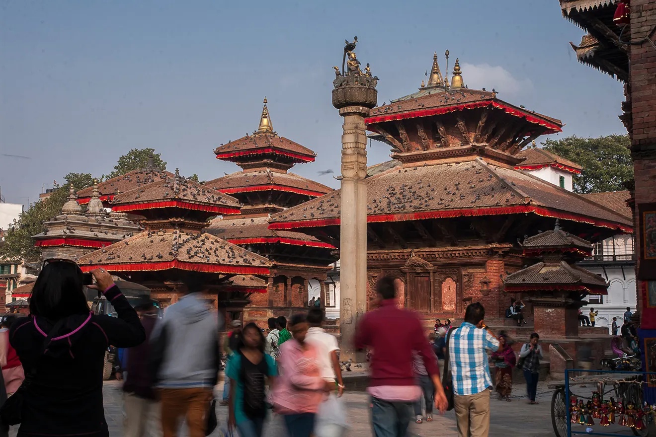 A bustling view of Kathmandu Durbar Square with ancient temples and pigeons, highlighting why the capital is among the best cities to visit in Nepal.