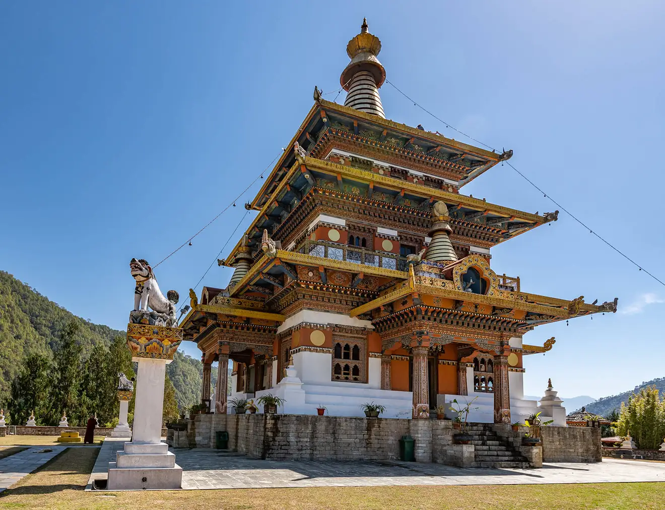 The ornate Khamsum Yulley Namgyal Chorten stands tall under a clear blue sky, a spiritual landmark visited during a professional Bhutan Botanical Tour.