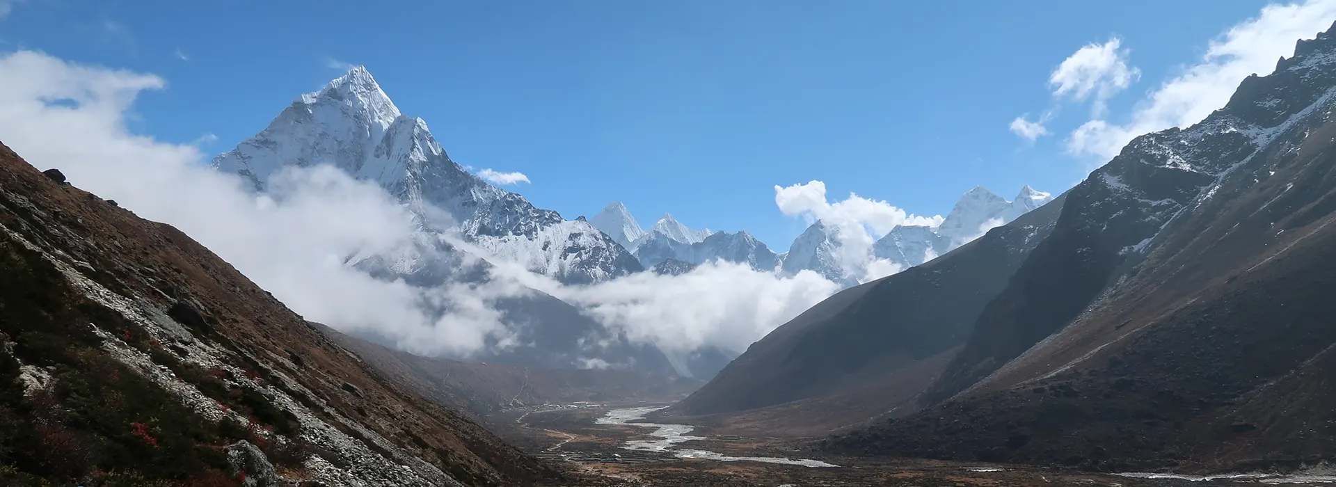 The majestic Ama Dablam mountain stands above a winding glacial river in the Khumbu region of Nepal. Understanding high-altitude logistics is key when planning your Nepal Trip Cost.