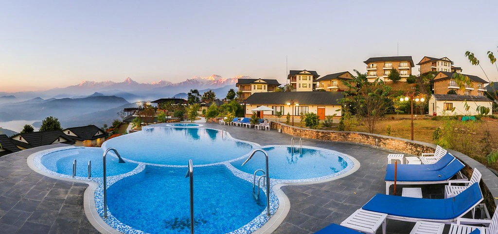 A luxury resort infinity pool overlooks the Annapurna mountain range at sunrise. This premium stay is a perfect addition to a 7-Day Nepal Itinerary.