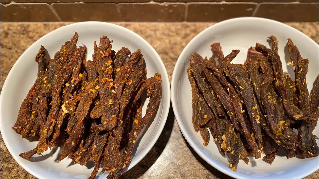 Two bowls filled with dried yak jerky sit on a stone counter. This traditional snack is a tasty example of what to buy in Tibet for your high-altitude trek.