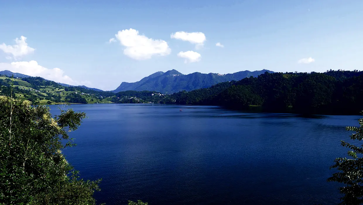 Traditional wooden boats rest on the quiet waters of Begnas Lake, a peaceful natural landscape that is one of the best places to visit in Pokhara.