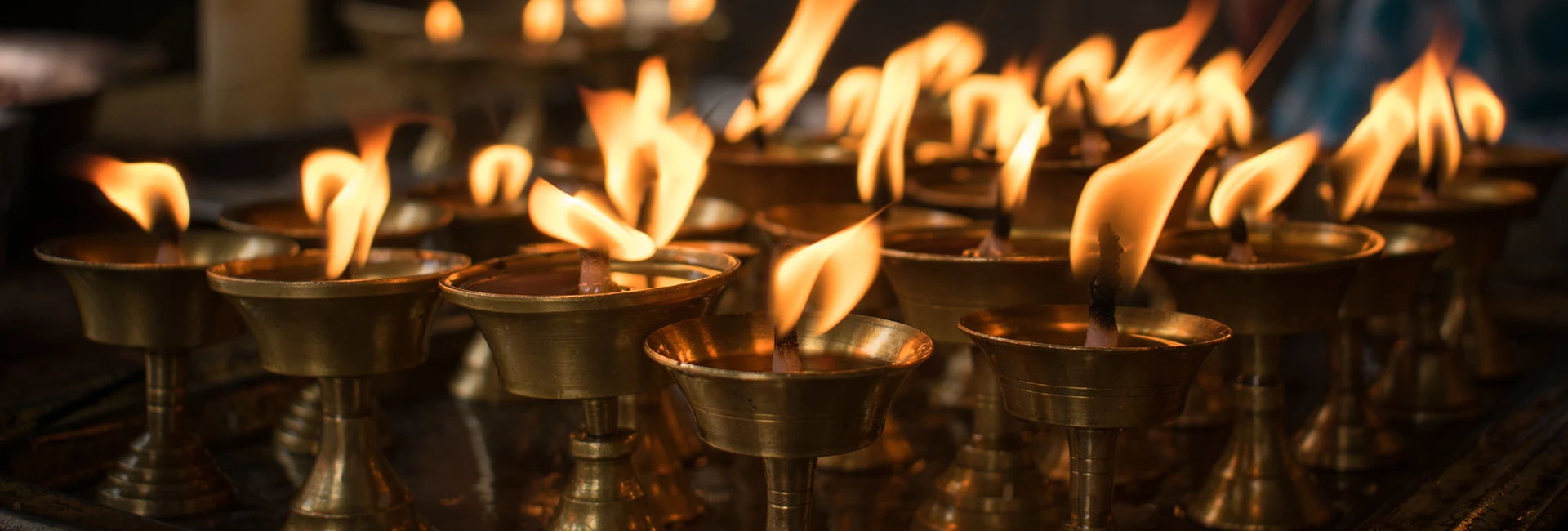 Dozens of golden butter lamps burn brightly inside a sacred temple, a cultural experience highlighted in a comprehensive Kathmandu Travel Guide.